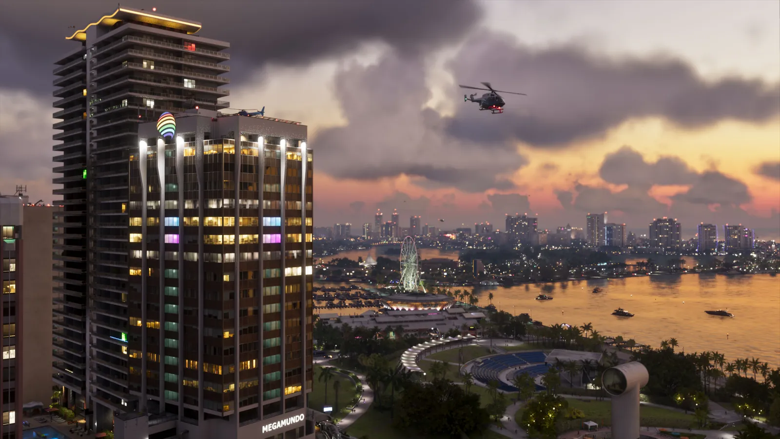 Megamundo Building in GTA VI: The Megamundo tower, with its flared white columns and name sign, rises over the bayfront park at sunset.