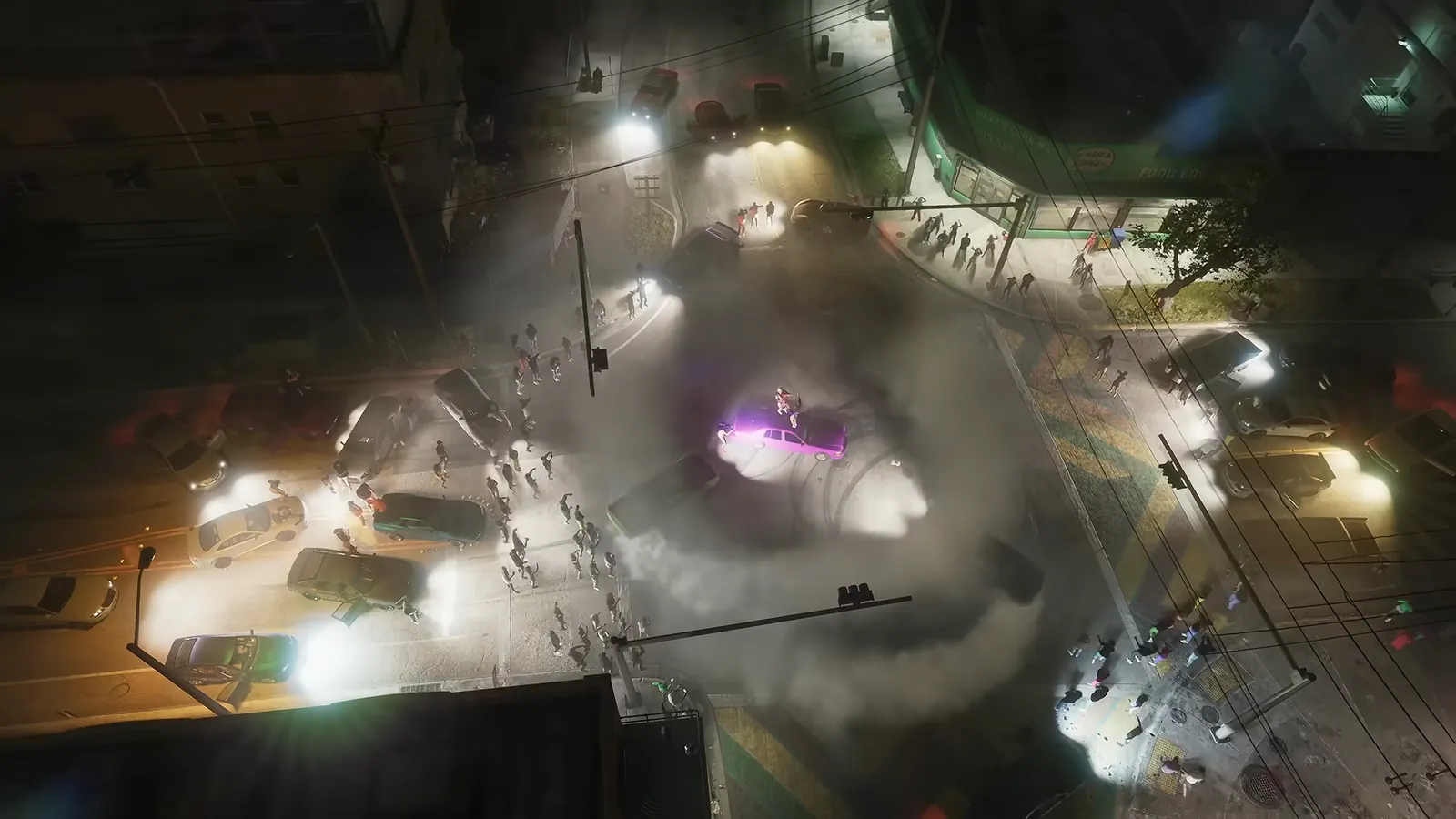 What's Cooking in GTA VI: Overhead night view of a street takeover as cars do doughnuts at a Crosstown intersection beside a corner store.